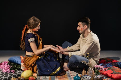 A Romantic Couple Holding Hands while Sitting