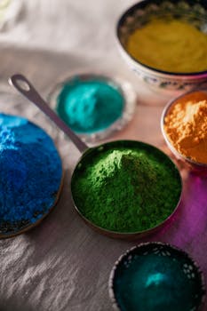 Assorted colorful powders for Holi festival arranged in decorative bowls with vibrant hues.