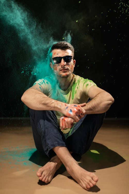 A Man Wearing Sunglasses Sitting on the Floor