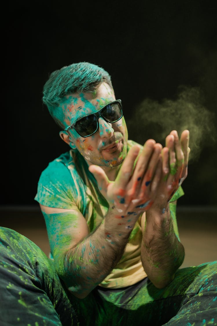 Man With Black Sunglasses Blowing Holi Powder On His Hands