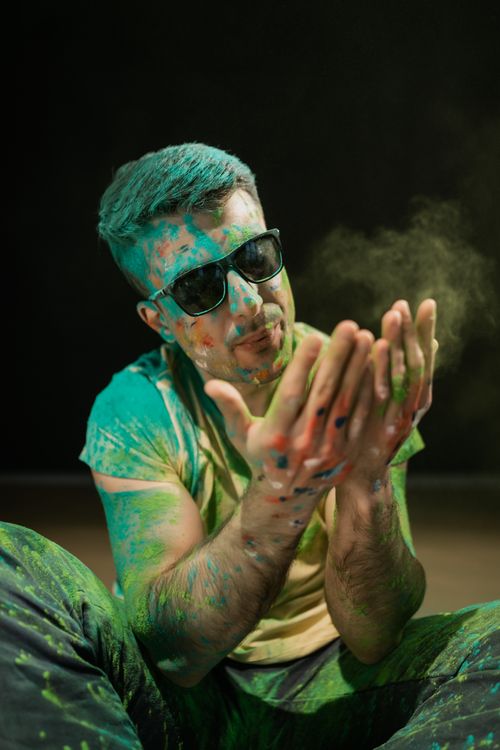 Free A joyful man covered in Holi colors wearing sunglasses, celebrating the festival. Stock Photo
