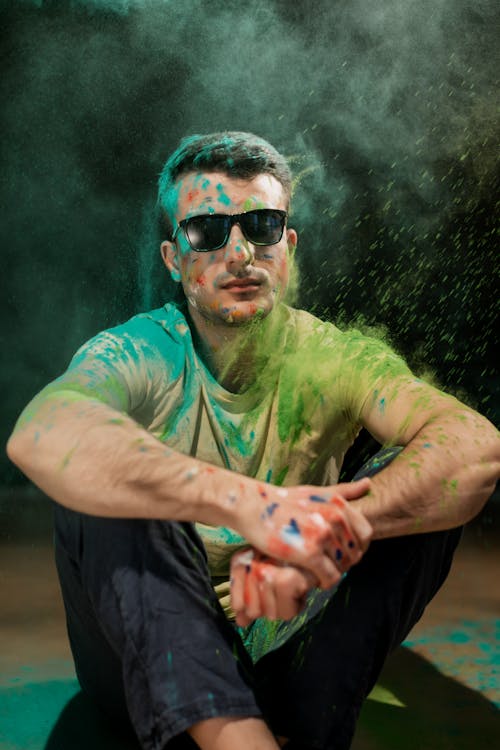 Man with Black Sunglasses Covered in Green Holi Powder