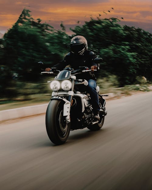 Free Man in Black Motorcycle Helmet Riding Motorcycle on Road Stock Photo