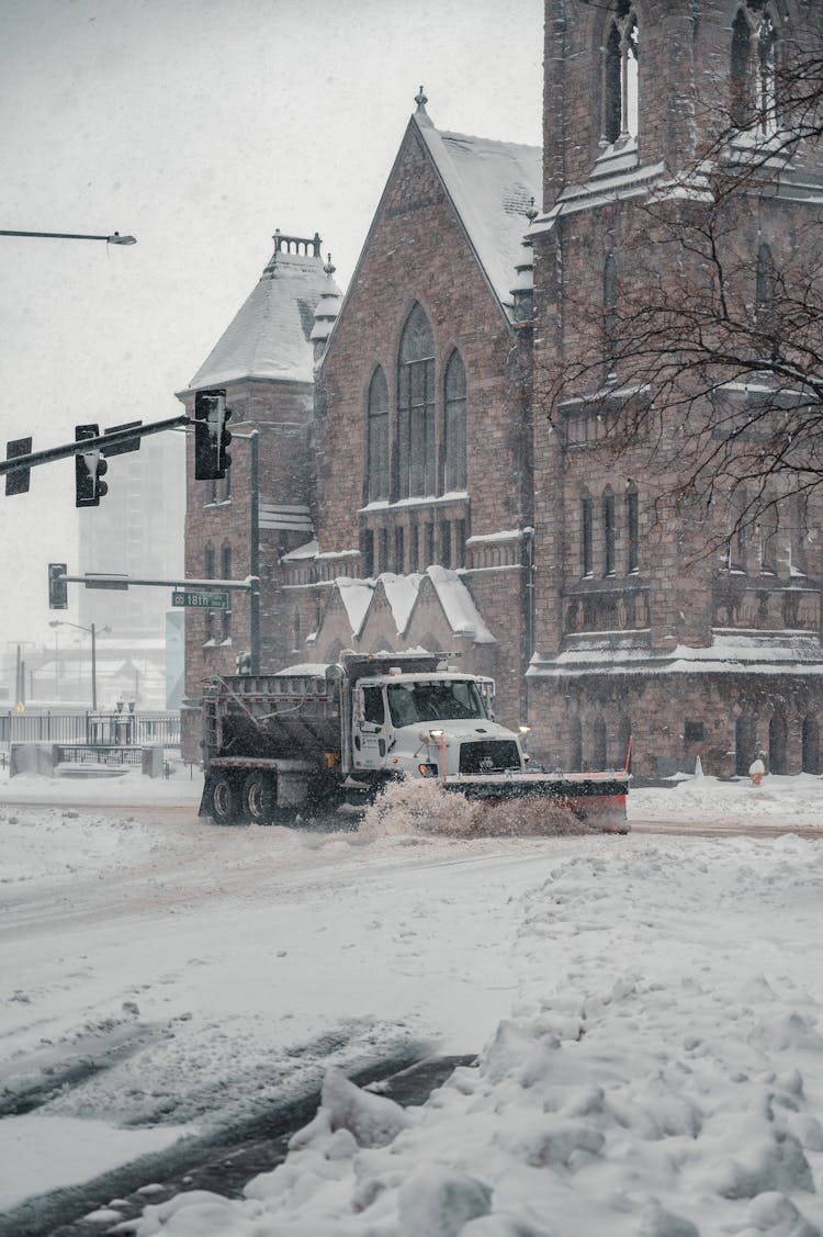 A Winter Service Vehicle Plowing The Snow On The Street