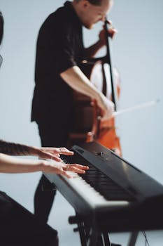 A pianist and a cellist perform passionately in an indoor setting.