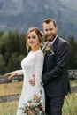 Man in Black Suit Jacket Hugging Woman in White Dress