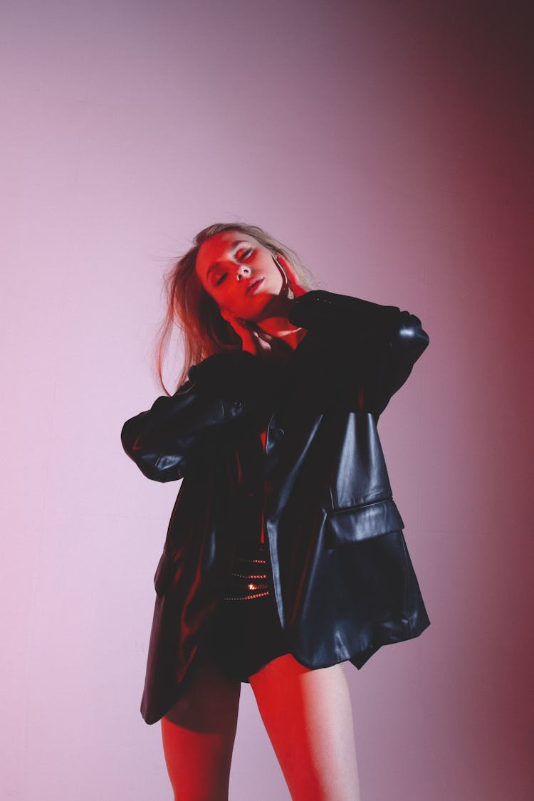 Serious Woman In Trendy Outfit In Studio With Red Lights