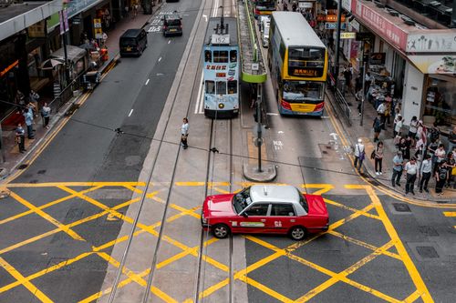 Free High-angle view of a bustling city intersection with trams, vehicles, and pedestrians. Stock Photo