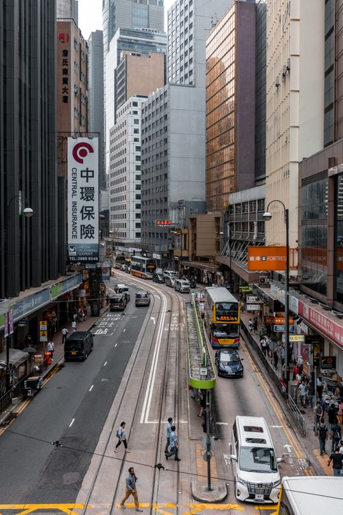 Free High-angle view of a busy urban street in Hong Kong with people, buses, and tall buildings. Stock Photo