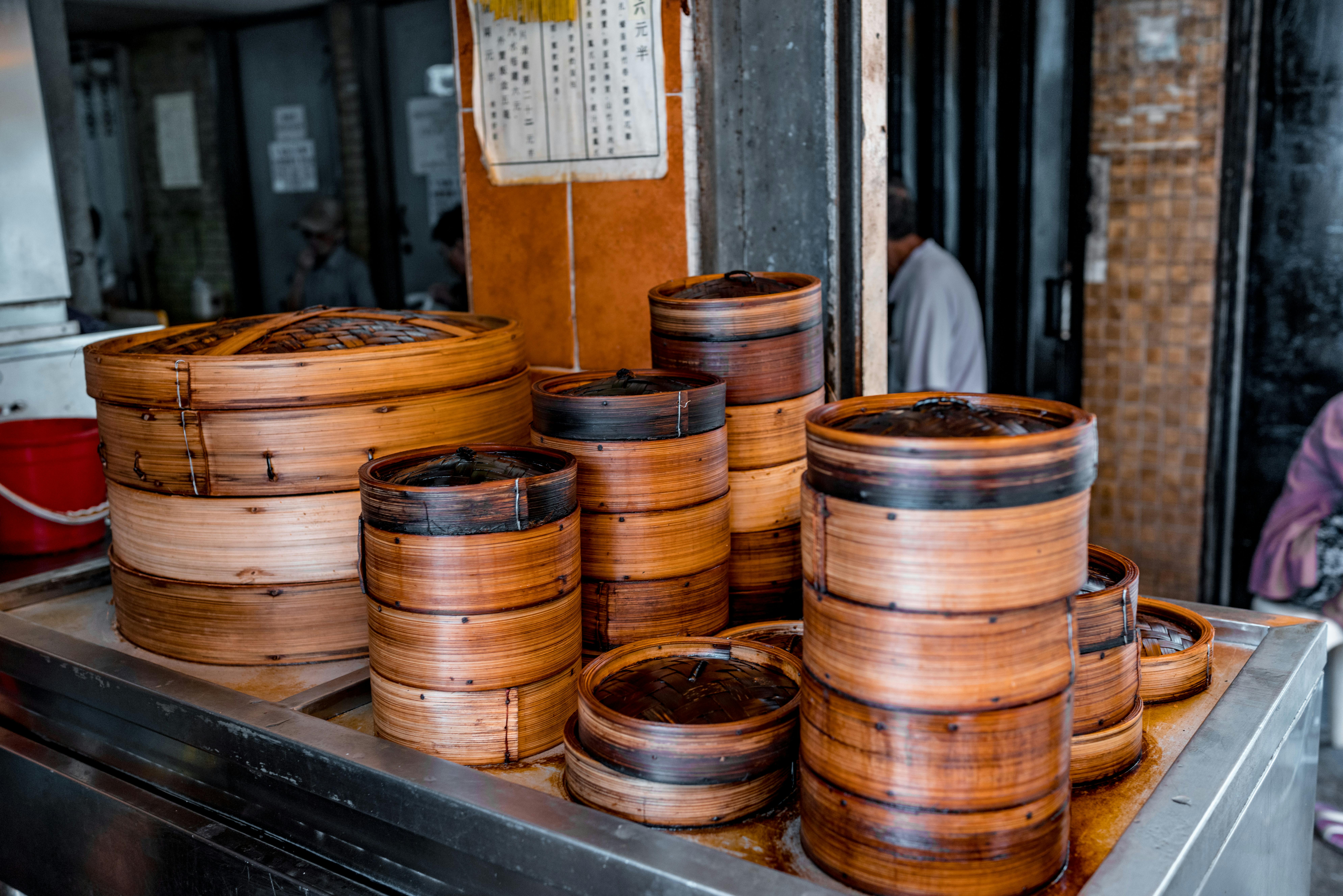 Piles of bamboo steamers in an authentic street food stall setting, showcasing rustic charm.