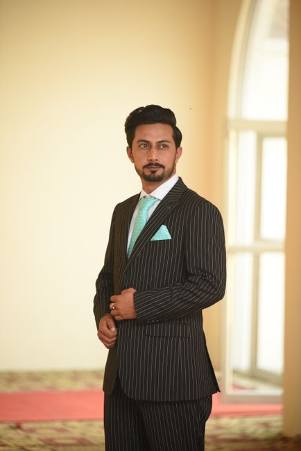 Portrait of a man in a pinstripe suit with a turquoise tie, indoors. - Understanding Dress Codes: Formal, Semi-Formal, Casual, and Traditional