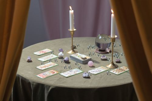 Free A magical tarot reading table set with lit candles, crystals, and tarot cards suggesting mysticism. Stock Photo