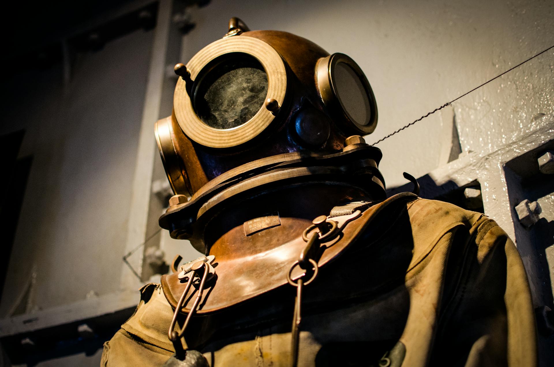 A vintage diving suit displayed in a museum, reflecting historical maritime exploration.