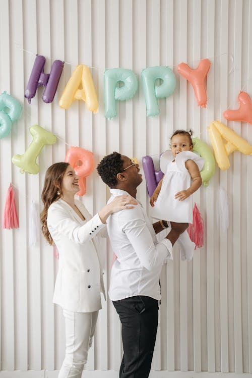 Free Couple Carrying Their Baby Girl Stock Photo