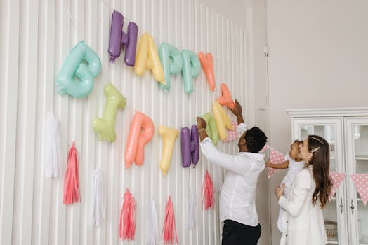 Family preparing a birthday celebration with colorful balloon letters indoors.