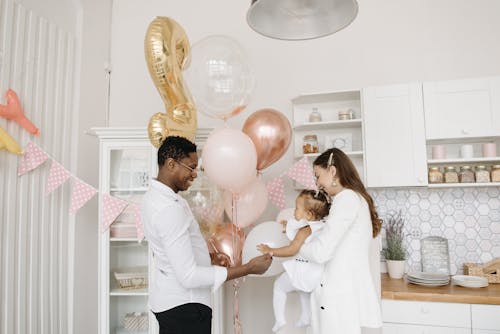Free Man Giving Balloons to Her Daughter Stock Photo