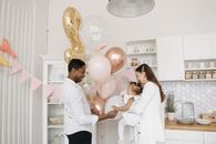 Woman in White Long Sleeve Shirt Holding Gold Balloons