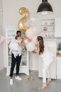 Happy family celebrating a birthday with festive balloons indoors.