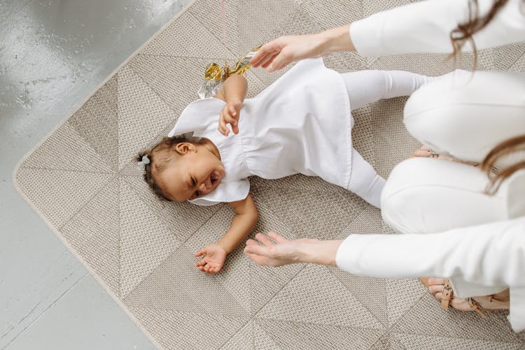 High-Angle Shot Of A Baby Girl Crying On The Floor