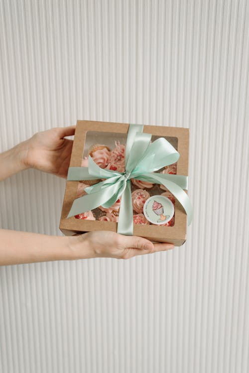 Close-Up Shot of a Person Holding a Box of Cupcakes