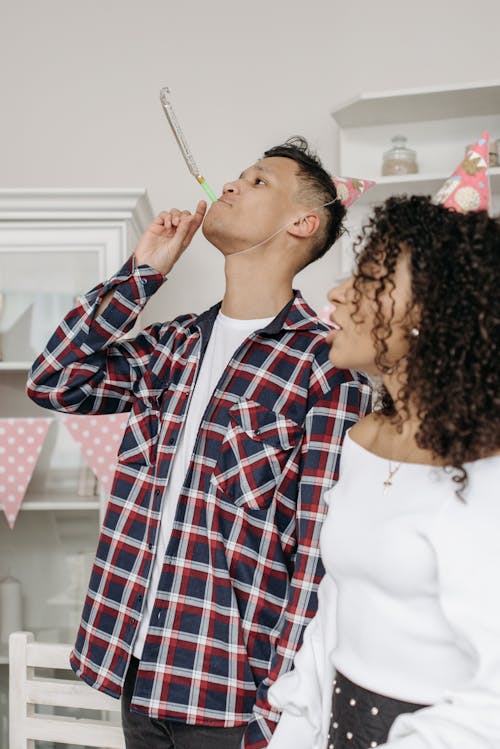 
A Man Blowing a Party Horn during a Birthday Party