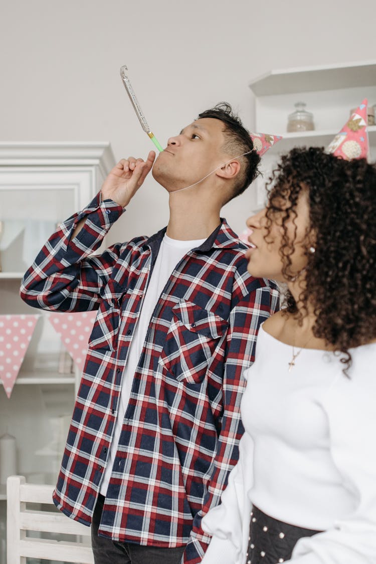 
A Man Blowing A Party Horn During A Birthday Party