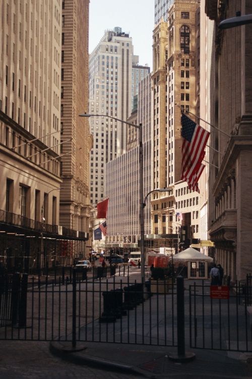 Free Downtown New York City street scene featuring American and Norwegian flags, iconic skyscrapers, and bustling activity. Stock Photo