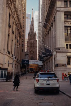 Urban scene of NYC street with police car and historic architecture.