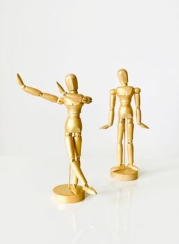 Artistic wooden mannequins posed creatively on a white background, perfect for artistic inspiration and still life studies.