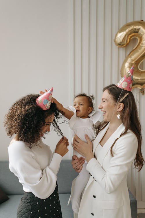Free A joyful celebration with family, including a baby and balloons, in a festive indoor setting. Stock Photo Free A joyful celebration with family, including a baby and balloons, in a festive indoor setting. Stock Photo