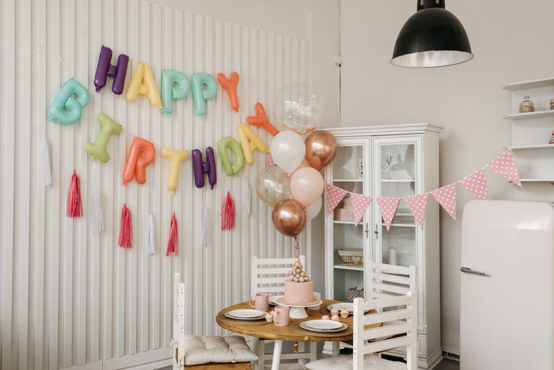 Bright birthday decoration scene with balloons, cake and coordinated party accessories