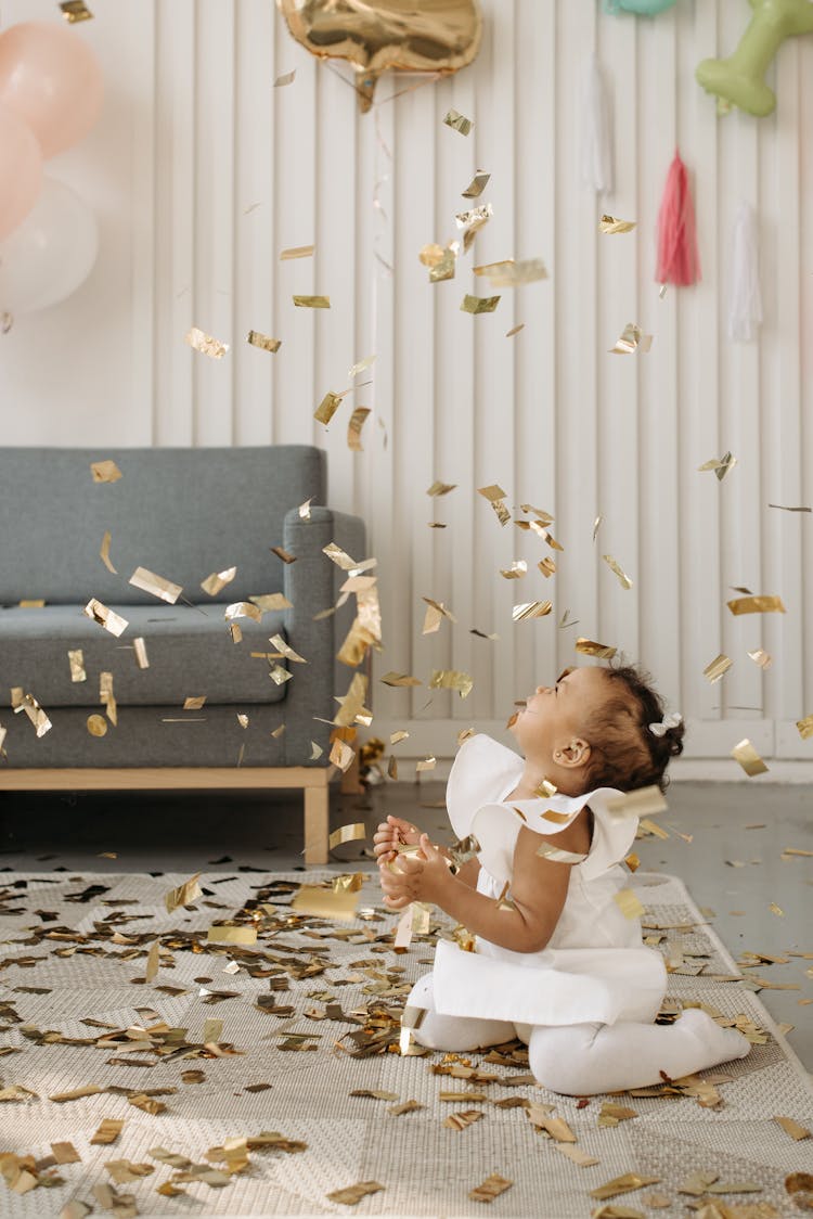 Confetti Flying While A Girl Is Sitting On The Floor