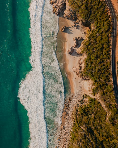 An Aerial View of a Beach with Crashing Waves on the Shore