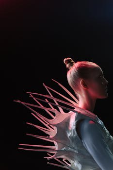 Side profile of a woman in a spiky, alien-themed costume against a black background.