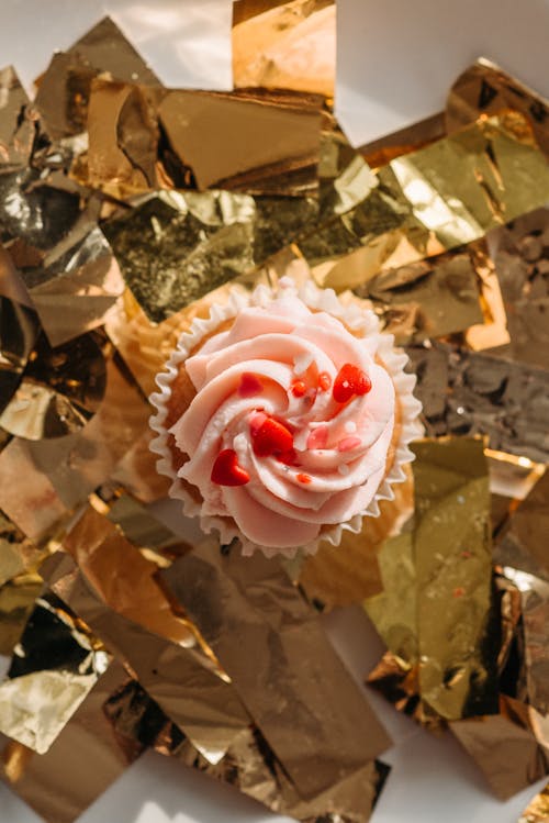 Top View of a Cupcake with Whipped Cream on Golden Confetti