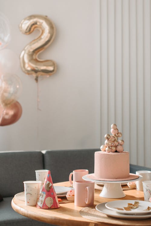 Free Wooden Table with Ceramic Plates and Cake for a Birthday Celebration Stock Photo