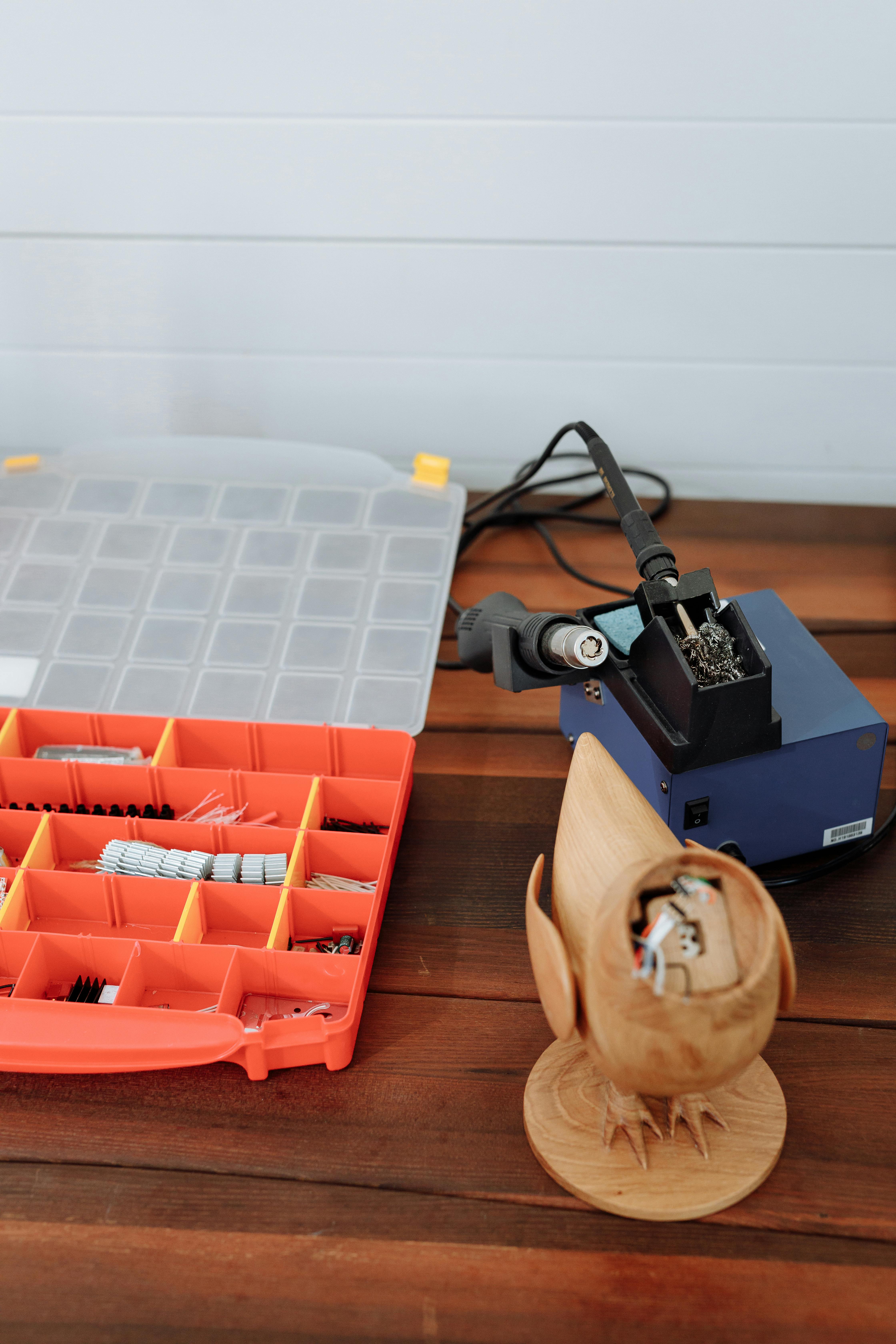 A well-organized workbench with various tools for disassembling and upcycling electronics, including screwdrivers, pliers, and a soldering iron.