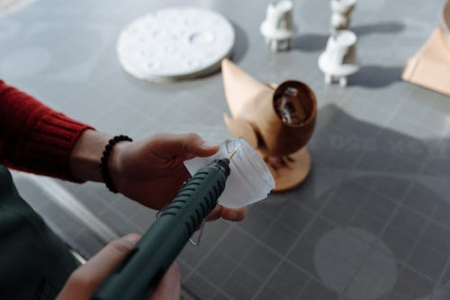 Person Putting Glue on the Dome Plastic Piece from a Glue Gun