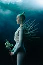 A Woman Wearing a Costume with Spikes Holding Flowers