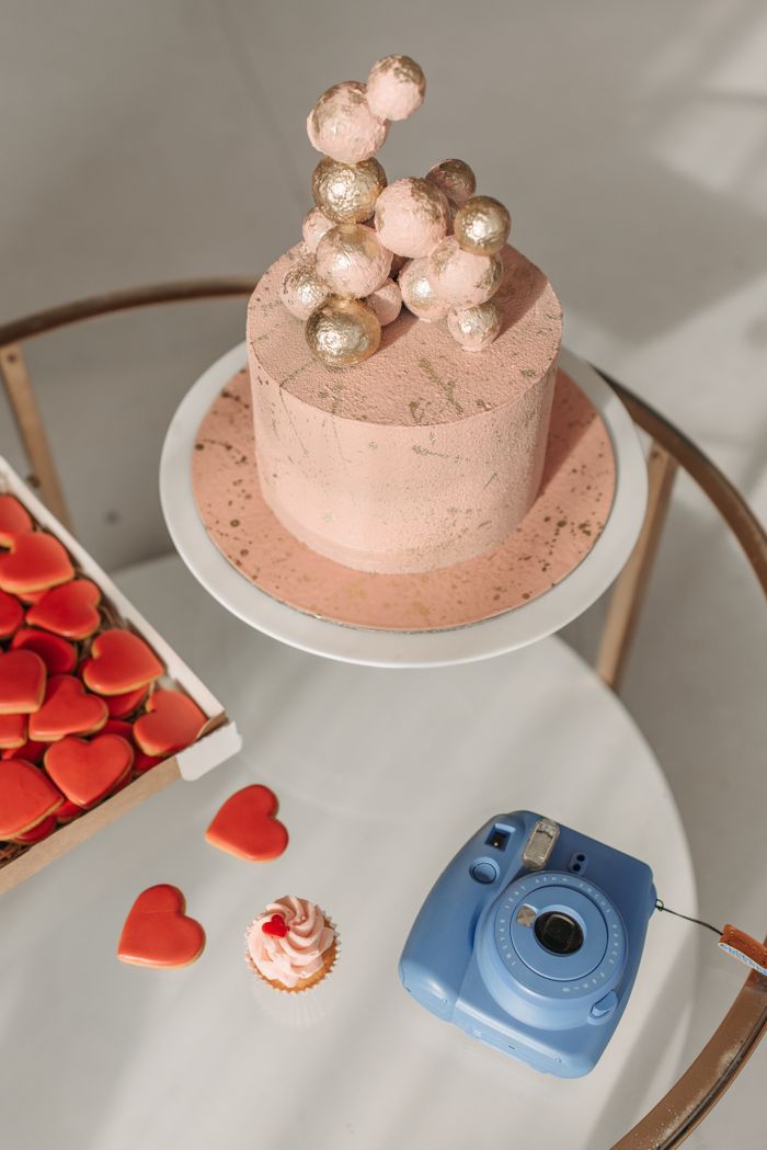 Pink frosted cake decorated with heart-shaped cookies — photo by Pavel Danilyuk on Pexels