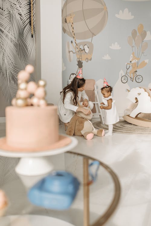 Free A Woman Holding a Plush Toy in Front of a Girl Stock Photo