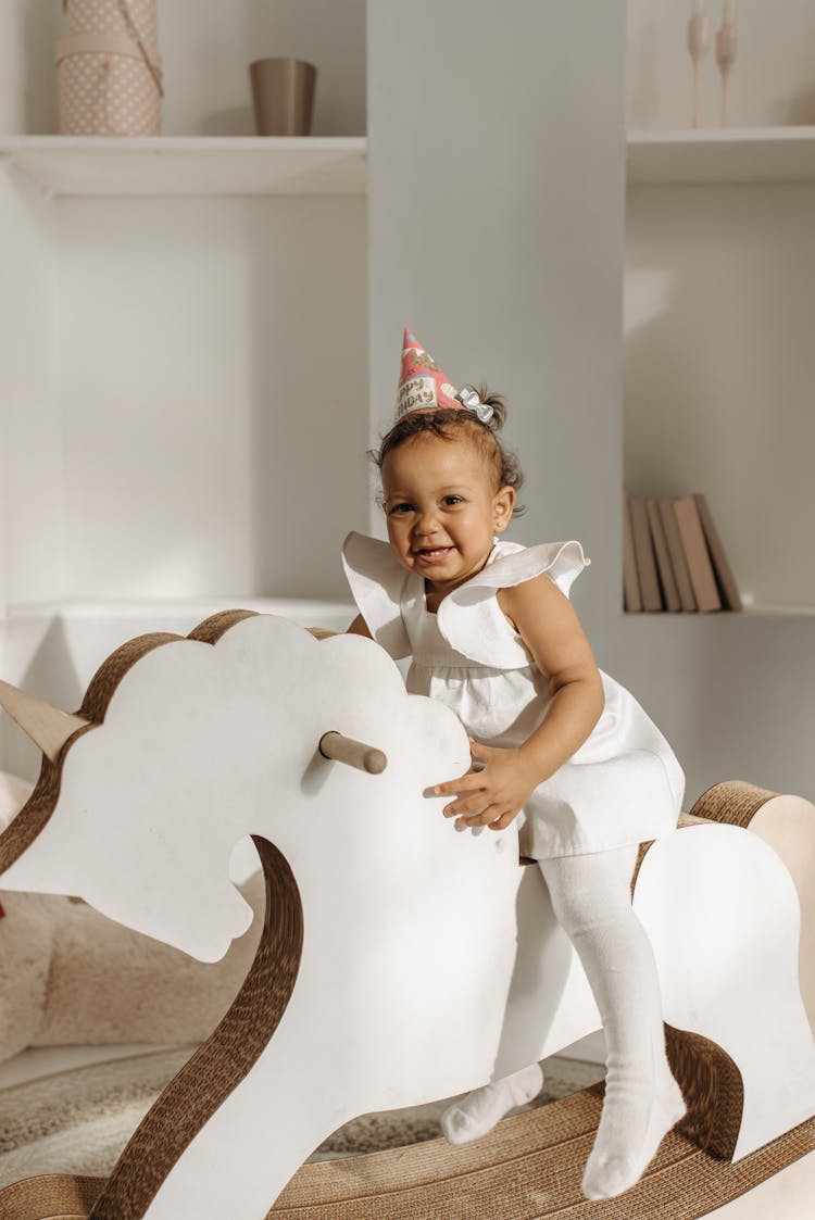 A Girl Riding A Toy Horse