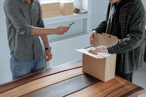 A Man Opening a Brown Cardboard Box