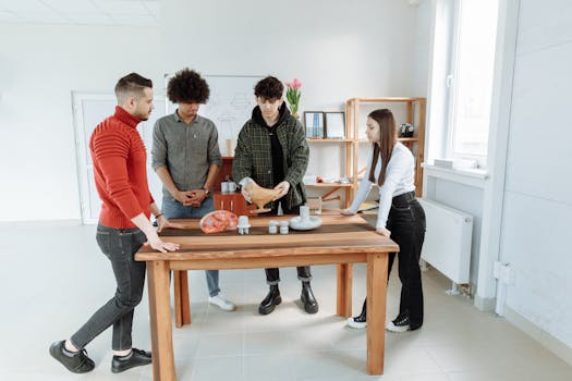 Four diverse adults discussing a project with anatomical models in a bright office setting.