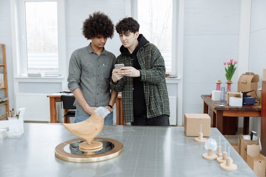 Two young designers assessing a bird sculpture prototype in a modern workspace, illustrating teamwork and innovation.