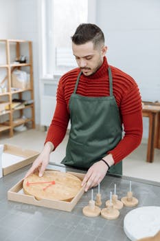 Man in red sweater unboxing a wooden wall clock, representing startup creativity in a modern workspace.