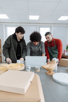 Three diverse colleagues working on a design project in a contemporary studio space.