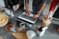 People Using a Laptop Computer to Discuss Product Design