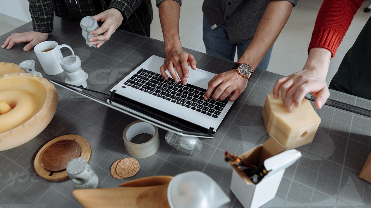 Product team discussing a niche AI SaaS opportunity around a laptop