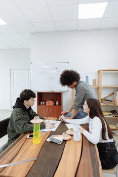 A group of young adults brainstorming ideas in a bright and modern office setting.